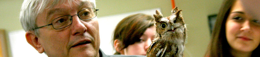 Dr. Huggins shows the rescue owl to students touring the department