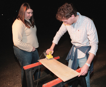 Assignment: Trading Spaces - Junior Jennifer Allen, art major, and junior Tyler Flatt, digital media studies major, work on sanding down the cabinet doors outside Hurt Commons.
