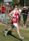 Grant Luke crosses the finish line during the Union University Cross Country Invitational.  Luke, also a member of the Union baseball team, receives applause from one of his teammates, Kevin Kirksey. - Photo by Steven Aldridge