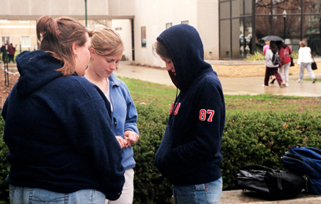 Union's Meredith Erlandson (left), Heather Moellman (center) and Stacy Storey pray for the students of Eastern Illinois University.