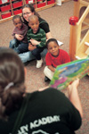 Lezli-O'Neal Sullivan holds two of the children in day care at the Salvation Army's Perdue Center of Hope while Julie Propst reads them a story during GO Memphis. - Photo by Justin Veneman