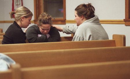 Union students Heather Moellman (left) and Meredith Erlandson (right) pray with an Eastern Illinois University student (center) during GO Illinois.