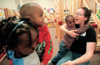 Freshman Lezli-O'Neal Sullivan, Spanish major, holds one of the day care children at the Salvation Army's Perdue Center of Hope during GO Memphis. - Photo by Justin Veneman