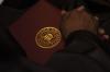 A graduate holds his newly, earned diploma during the fall graduation ceremony. - Photo by Beth Spain