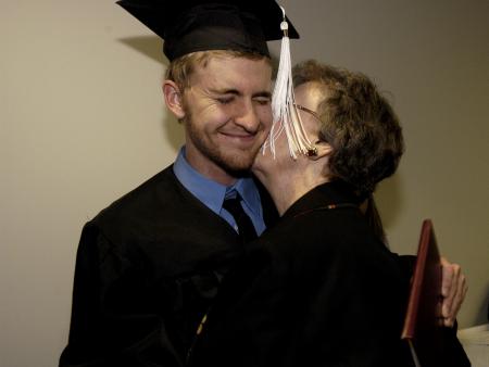 Mathew Lowell, public relations and advertising major, receives hugs and kisses from his grandmother after the fall graduation ceremony.
