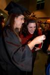 Rindi Tennyson, accounting graduate, looks at her camera with her friend, Laura Byrd, after the fall graduation ceremony. - Photo by Angela Abbamonte
