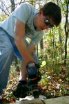 Chad Keathley, junior theology major, drills a hole in a bog bridge sleeper where a steel ground stake (rebar) will then be placed. - Photo by Kristi McMurry