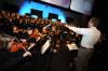 Music chair Chris Mathews warms up 250-voice community choir and 30-piece orchestra before <em>Remembering Feb. 5: An Evening of Thanksgiving</em>. - Photo by Morris Abernathy