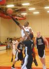 Sophomore forward Antoine Joseph lays the ball in the basket over defenders. - Photo by Morris Abernathy