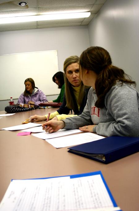 Students participating in the Language capstone group look over each other's papers.