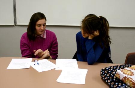 Blair Hoglen, senior intercultural studies major, and Sarah Logan, senior business administration major, critique each other's papers for the Language capstone group.