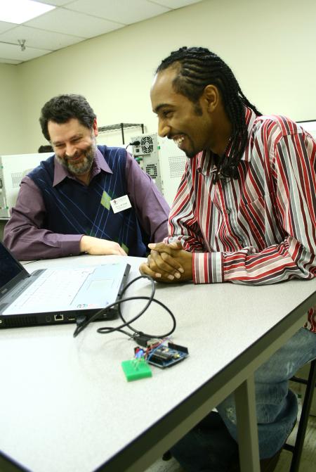 Jan Wilms, chair of the computer science department, oversees a project that Mikias Seid, sophomore computer science major, has put together. 