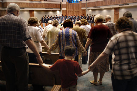 Community members joined hands across the aisles during prayer at the citywide prayer service held at First Baptist Church, Jackson.