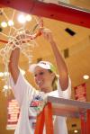 Kayla Hudson cuts down a piece of the net at Oman Arena after winning the 2009 NAIA championship. - Photo by Kristi McMurry