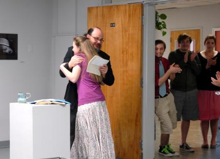 Lee Benson, art department chair, congratulates Kelsey Roberts, junior art major, on her three awards for the annual student show.