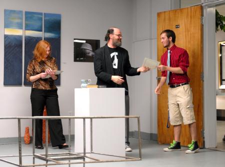 Lee Benson, art department chair, congratulates Caleb Booth, sophomore art major, on his scholarship award. 