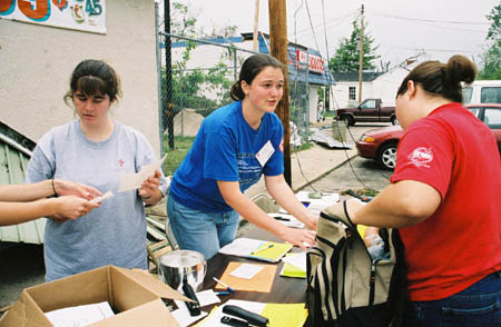 Meredith Williams gives Sarah Hubbard an area to distribute food in as Rebecca Carlson looks at needs assestment forms for a family.