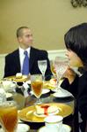 Brandy Hudgins, career services secretary, enjoys her water at the 2009 Etiquette Luncheon as Mark Mogel, senior management major, watches a powerpoint on interview etiquette. - Photo by Kristi McMurry
