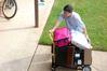 Don Van, professor of Engineering, rolls a cart of belongings to a student's room on freshman move-in day. Many faculty, staff, and students pitched in to help the freshmen move into their rooms. - Photo by Kristi McMurry