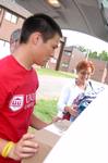 Peter Yu, sophomore, helps Christy Krone, mother of Elsie Krone, move her daughter's belongings to her room on freshman move-in day. - Photo by Kristi McMurry