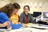 Katherine Crutcher, Kristen Marks, both sophomore art majors, and Allison Little, junior DMS major, look through sample designs from a recent graphic design conference during their AIGA meeting. - Photo by Kristi McMurry