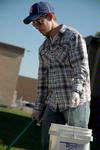 Joshua David Creswell, junior philosophy major, picks up trash at the Hartland Place apartments during Campus and Community Day. - Photo by Beth Spain