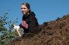 Ashley Nabors, senior nursing major, participates in shoveling mulch around trees at Liberty Park during Campus and Community Day. - Photo by Beth Spain