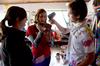 Kate Allen, sophomore graphic design major, Maddie Russo, sophomore elementary education major, and Caleb Booth, junior art major, carefully mix paint for the mural at Daddy's Kitchen Table Soup Kitchen on Campus and Community Day. - Photo by Megan Bailey