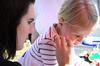 Anna Elrod, freshman athletic training major, paints a butterfly on the face of Kendall Morris, 4, at the Kappa Delta tent during Arts in the Park for Homecoming 2009. - Photo by Megan Bailey