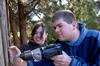 Will Miller, freshman Christian Studies major, and Camille McCullar, senior history major, mount a board for a building project completed by the history department at Green Frog Village on Campus and Community Day.  - Photo by Kristi McMurry