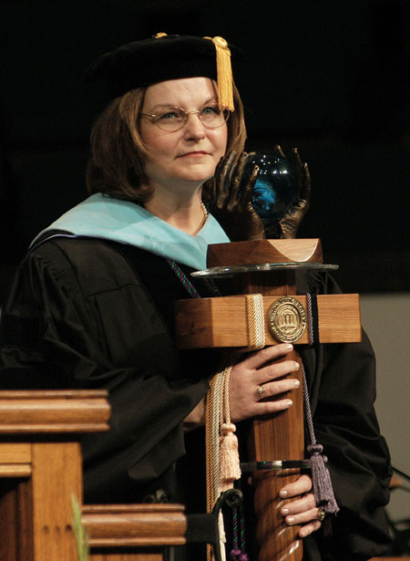 Faculty member of the year Dr. Anne Singleton presents the mace during the August 2003 commencement exercises.