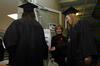 Jessica Vanderpool, journalism graduate, sanitizes her hands as the graduates walk to participate in the fall graduation ceremony. - Photo by Sarah Palmer