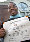 Graduate Patrick Washington proudly displays his Education Specialist degree in front of West Jackson Baptist Church shortly after the August 2003 commencement exercises. - Photo by Jim Veneman