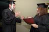 Wagner Oliveira, DMS-Art graduate, and Amanda Middleton, Art graduate, practice shaking hands with President Dockery before Union's fall graduation ceremony begins. - Photo by Beth Spain