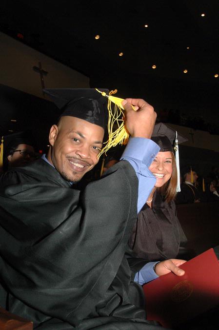 Marshal Brown, physical education and health graduate, switches his tassel from right to left as Ashley Bugg, learning foundations graduate, looks on during fall graduation.