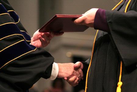President Dockery shakes hands with each graduate as he presents them with their diploma during fall graduation.