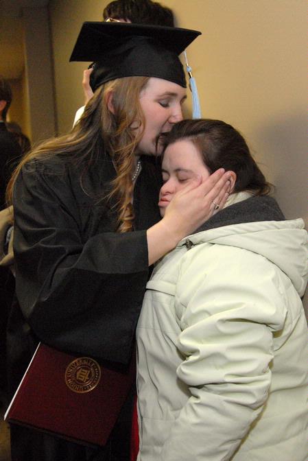 Emily Babin Campbell gives her sister, Elizabeth Babin, a kiss after graduating with a bachelor of science in special education at fall graduation. 