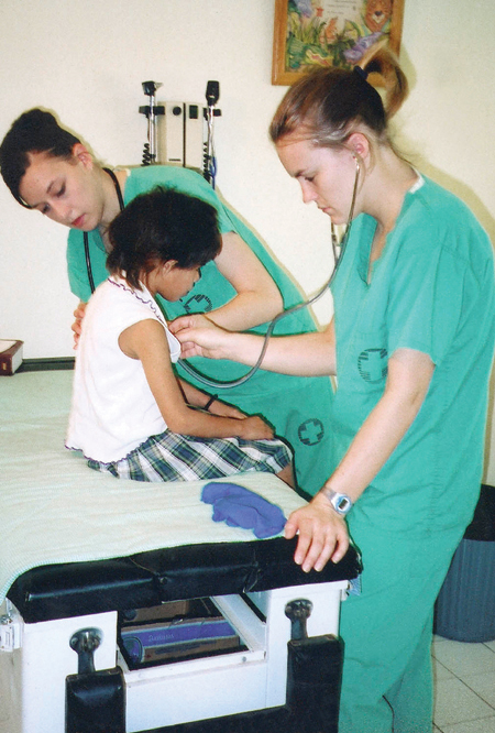 Nursing students Kari Noblett and Amy Rennie provide basic physicals and treat minor illnesses for children at Orphanage Emmanuel while serving on the GO Hondurus team.