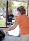 Tessa Dice of Galatin, Tenn. takes the easy way to her dorm room by passing her mother a mirror through her dorm room's window during FOCUS 2003. - Photo by Lindsay Stavish