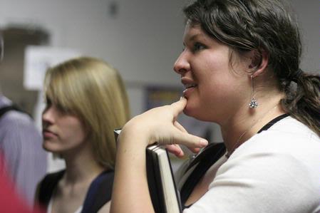 Mallory Carter, senior business administration major, listens to a presentation by one of her graphic design classmates. 