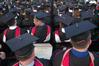 Masters graduates review their diplomas during the Spring 2010 graduation ceremony. - Photo by Beth Spain