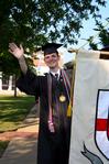 Noah Arnold, graduating history major, waves to family and friends during the processional for the 2010 spring commencement ceremonies. - Photo by Ebbie Davis