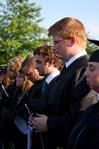 Along with other graduates, Josh Allen and Joseph Ball bow their heads during the invocation led by James Shaddix.  - Photo by Ebbie Davis