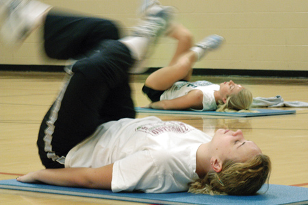Freshman Sabrina White, history major, does some abdominal work during the early morning hours on Friday. She keeps an eye on her aerobics instructor, sophomore Emily Kuhnert, athletic training major.