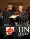 President David S. Dockery presents Rich Grimm, senior vice president for enrollment services, with a plaque in honor of his new role at the university.  - Photo by Morris Abernathy