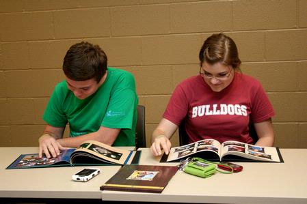 Wil Story, sophomore public relations major, and Amelia Krauss, junior journalism major, look through photo albums of Angel, Fonsi and Lesley Guilaran's adopted child. 