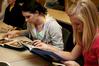 AlLee Browning, sophomore elementary education major, and Sarah Chitwood, junior English and elementary education major, look through photo albums of Angel, Fonsi and Lesley Guilaran's adopted child. - Photo by Deanna Santangelo