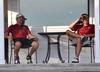 Brett Barry (left) and Micah Gentle rest after their rounds as they watch teammates come in off the course. - Photo by Steven Aldridge