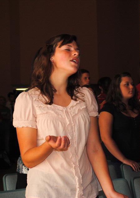 Jenny Voss, freshman applied linguistics major, sings along to "It is Well" during a chapel service. 
