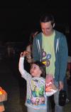Nathan Fisher, senior English major, helps his little sister Savannah make her way to their spot to watch Toy Story 3 for Movie on the Lawn. - Photo by Victoria Stargel